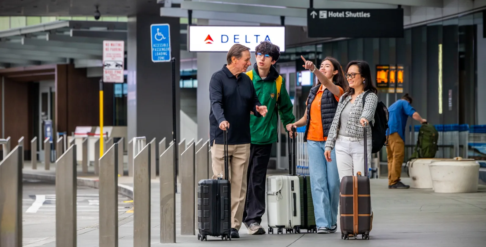 A group of four passengers on the Departures curb of SFO